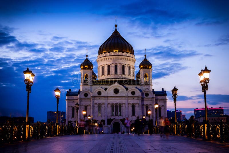 Illuminated Cathedral of Christ the Savior framed with old style street lights of Patriarchy Bridge at night