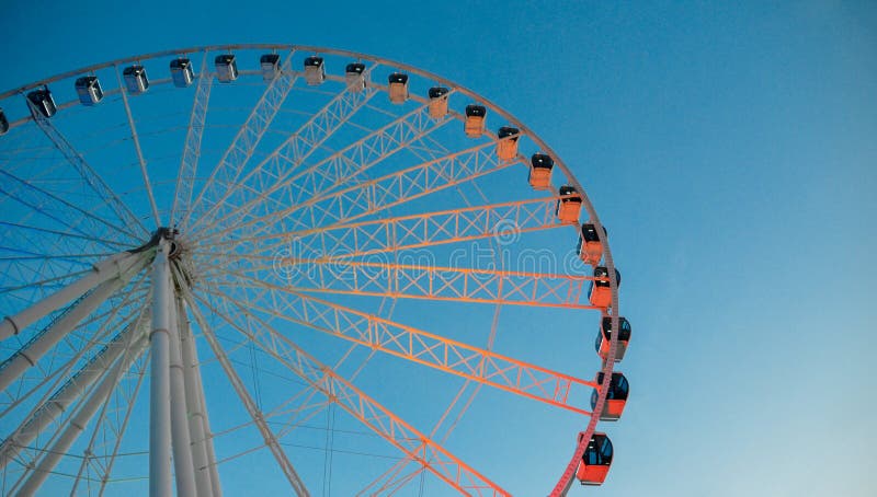 Illuminated ferris wheel at dusk on a blue sky. stock photo Illuminated ferris wheel at dusk on a blue sky. stock photo