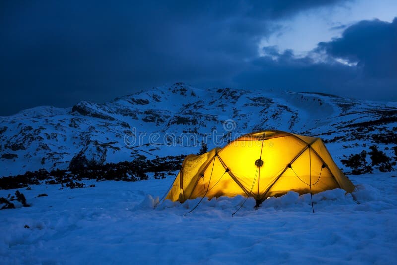 Illuminated Yellow Tent in a Wintry Blue Landscape Stock Photo Image