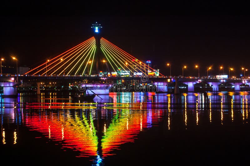 Illumination on Han River Bridge in Danang. The bridge crosses the Han River but in the middle of the night it swings on its axis to allow shipping traffic to pass along the river. Illumination on Han River Bridge in Danang. The bridge crosses the Han River but in the middle of the night it swings on its axis to allow shipping traffic to pass along the river.