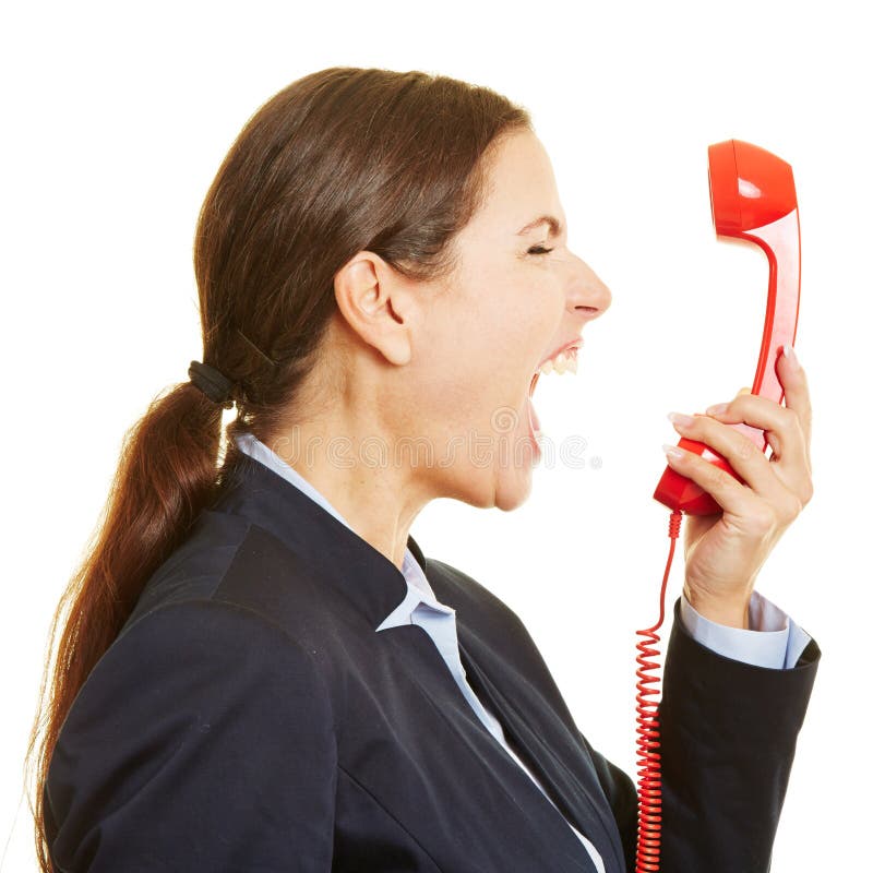 Angry businesswoman screaming loudly into a red phone. Angry businesswoman screaming loudly into a red phone