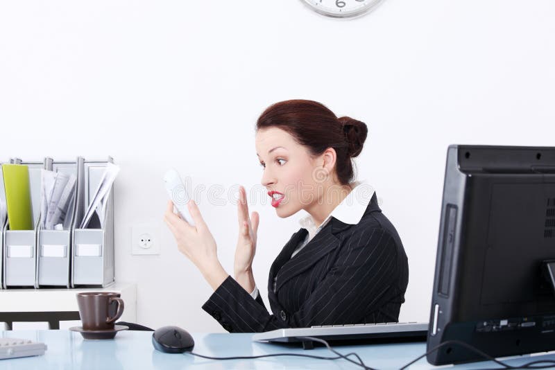 Pretty caucasian businesswoman screaming to phone in the office. Pretty caucasian businesswoman screaming to phone in the office.