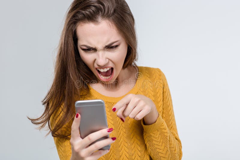 Portrait of angry woman screaming on the phone isolated on a white background. Portrait of angry woman screaming on the phone isolated on a white background