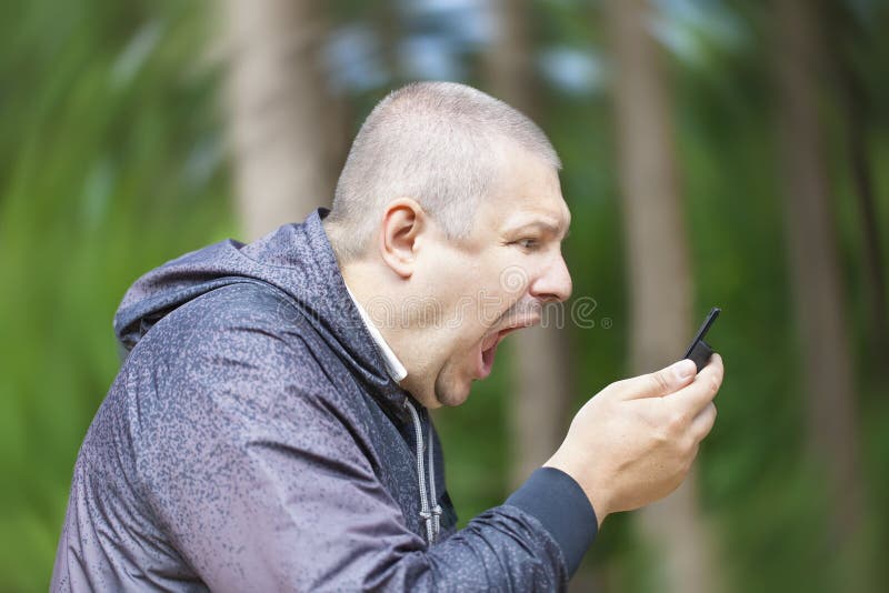 Angry man screaming in phone on the rotating background. Angry man screaming in phone on the rotating background