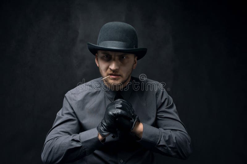 Ilsken och aggressiv man med en tandpetare i hans mun, mot en mörk bakgrund arkivfoto Ilsken och aggressiv man med en tandpetare i hans mun, mot en mörk bakgrund arkivfoto