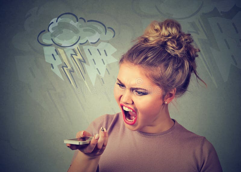 Portrait angry young woman screaming on mobile phone isolated on gray wall background. Negative human emotions feelings. Portrait angry young woman screaming on mobile phone isolated on gray wall background. Negative human emotions feelings