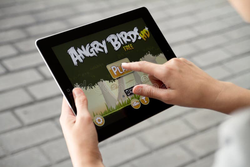 A woman outdoors play in the game Angry Birds on Apple Ipad2. A woman outdoors play in the game Angry Birds on Apple Ipad2.