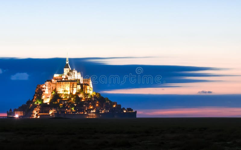 Iluminujący Mont saint michel przy półmrokiem w colourful niebie z chmurami na lecie, Francja zdjęcie stock Iluminujący Mont saint michel przy półmrokiem w colourful niebie z chmurami na lecie, Francja zdjęcie stock