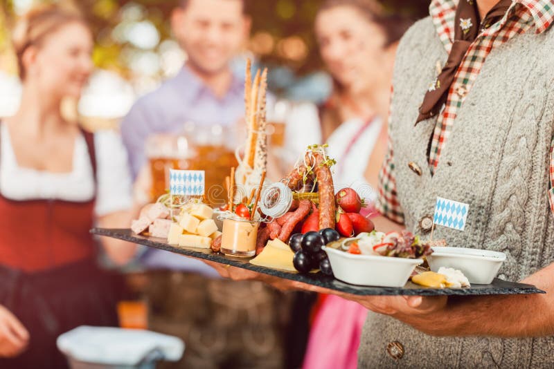 Im Biergarten - Bier und Snäcke dienten bei Oktoberfest lizenzfreie stockfotografie Im Biergarten - Bier und Snäcke dienten bei Oktoberfest lizenzfreie stockfotografie