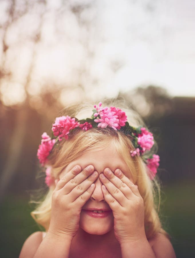 Im invisible. a cheerful little girl with her hands on her eyes playing hide and seek outside in nature. Im invisible. a cheerful little girl with her hands on