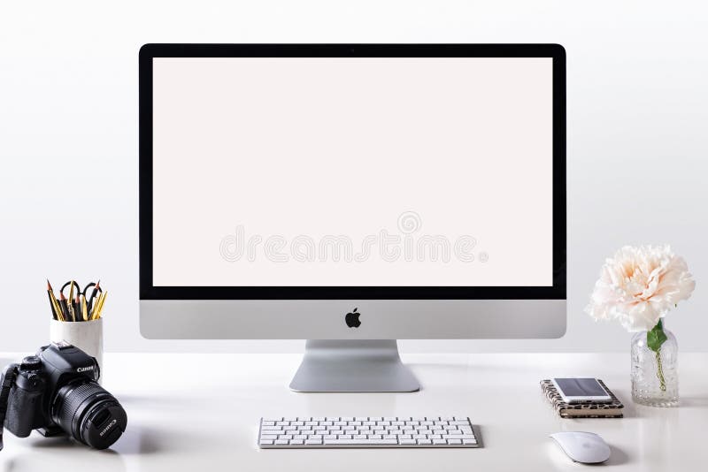 IMac desktop computer on table styled photo. Mock-up with a blank screen, front view