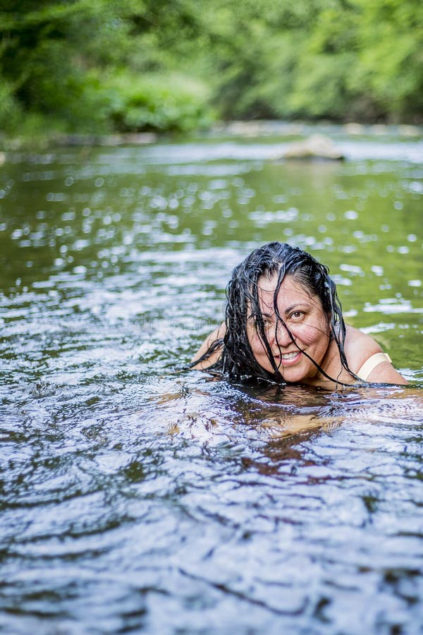 Image of a beautiful woman with long black hair partly in her face enjoying a day in the river stock photography Image of a beautiful woman with long black hair partly in her face enjoying a day in the river stock photography