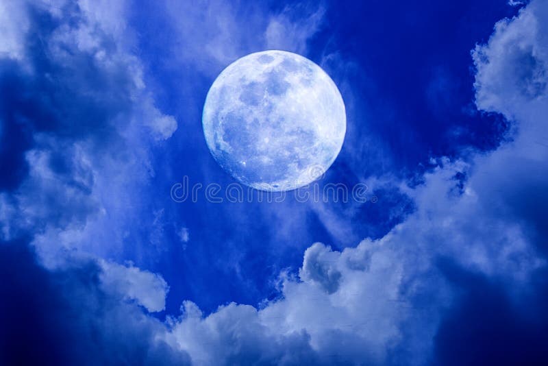 Image of big bright full moon glowing in the blue sky with clouds at night during a light rain. Image of big bright full moon glowing in the blue sky with clouds at night during a light rain.