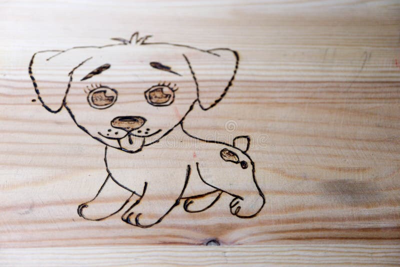 Pyrography wood burning picture of the funny puppy on wooden surface. Pyrography wood burning picture of the funny puppy on wooden surface