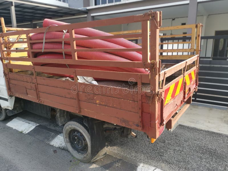 Bundle of Vermilion Red PVC Plastic Industrial Pipe Hose at the Back of