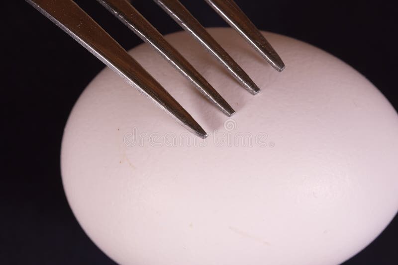 Closeup of a fork on a piece of sausage royalty free stock photography