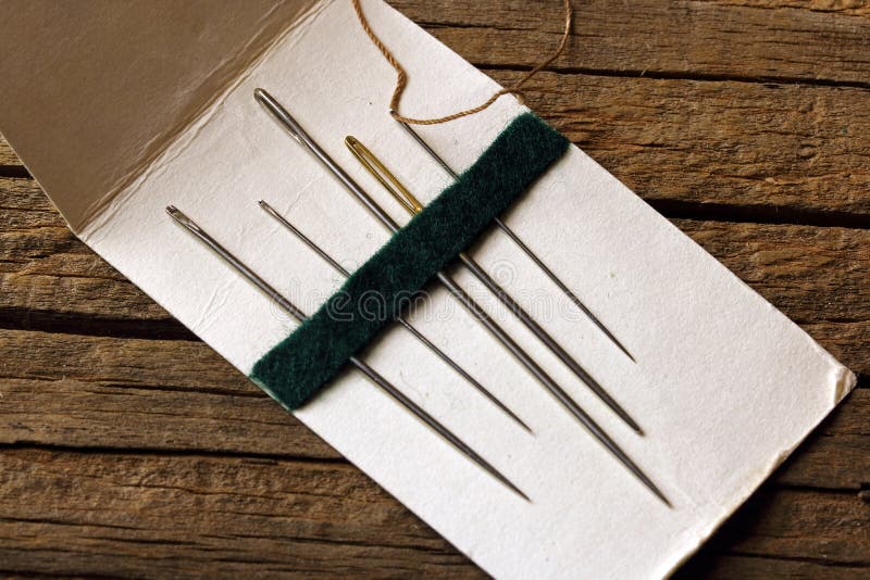 ASSORTED SEWING and DARNING NEEDLES on a CARD with a THREAD in ONE