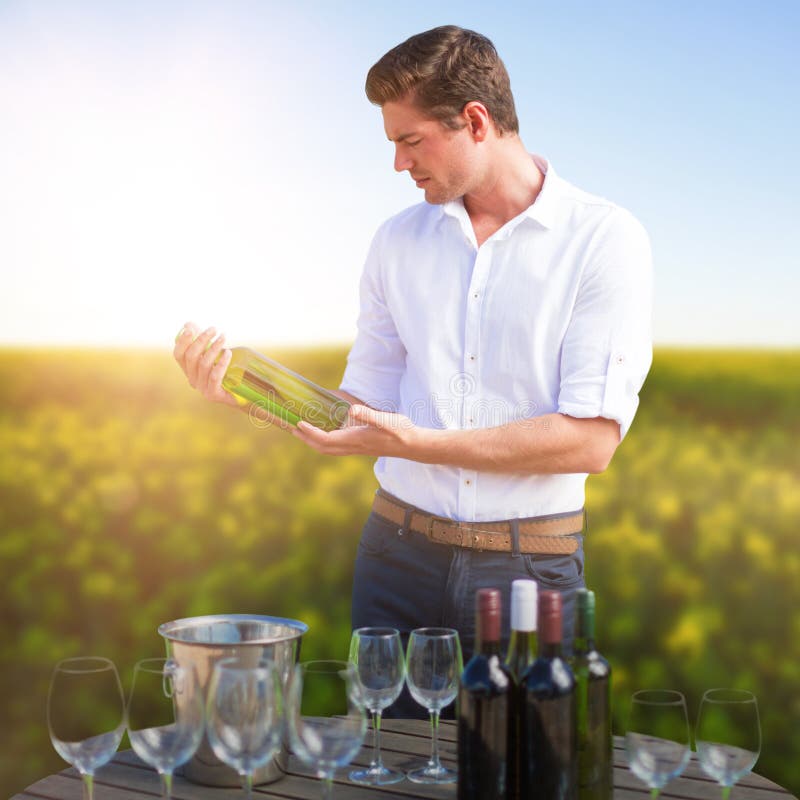Image composée de jeune homme tenant la bouteille de vin par des verres sur le baril images libres de droits Image composée de jeune homme tenant la bouteille de vin par des verres sur le baril images libres de droits