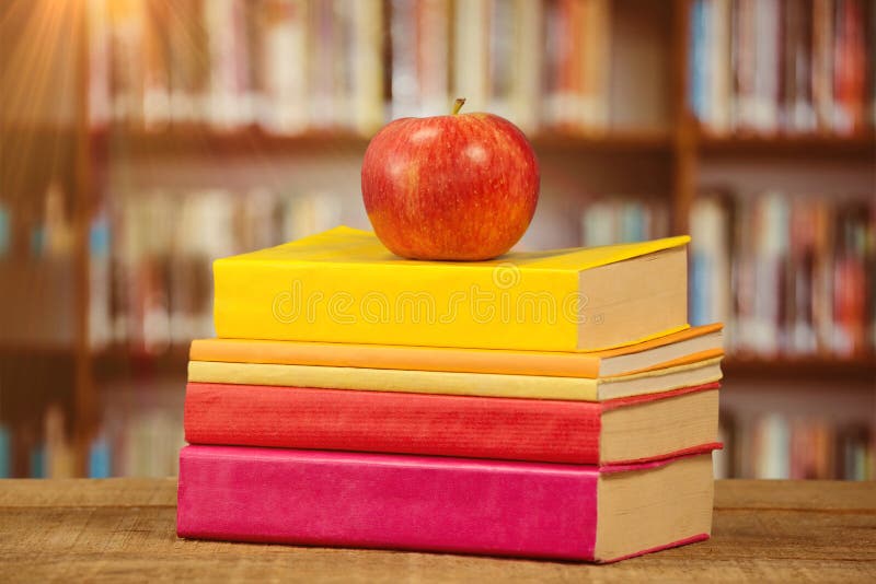 Image composée de pomme avec des livres sur la table. Apple avec des livres sur la table contre l'étagère de bibliothèque