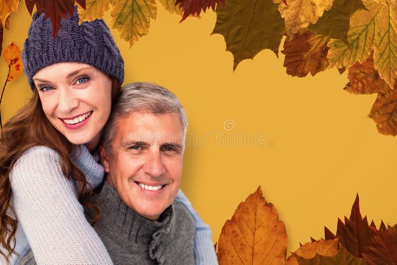 Happy couple in warm clothing against autumn leaves pattern. Happy couple in warm clothing against autumn leaves pattern