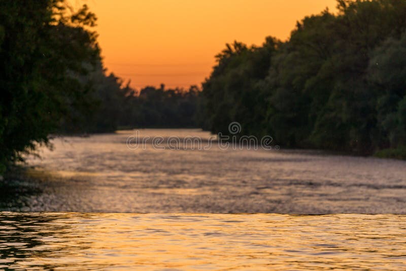 Image de couleurs se reflétantes de rivière pendant le coucher du soleil photographie stock libre de droits Image de couleurs se reflétantes de rivière pendant le coucher du soleil photographie stock libre de droits