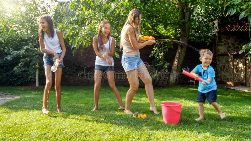 Image de la jeune m?re de wuth gai heureux d'enfants jouant avec les armes ? feu d'eau et la maison de jardin Famille jouant et a photos libres de droits Image de la jeune m?re de wuth gai heureux d'enfants jouant avec les armes ? feu d'eau et la maison de jardin Famille jouant et a photos libres de droits