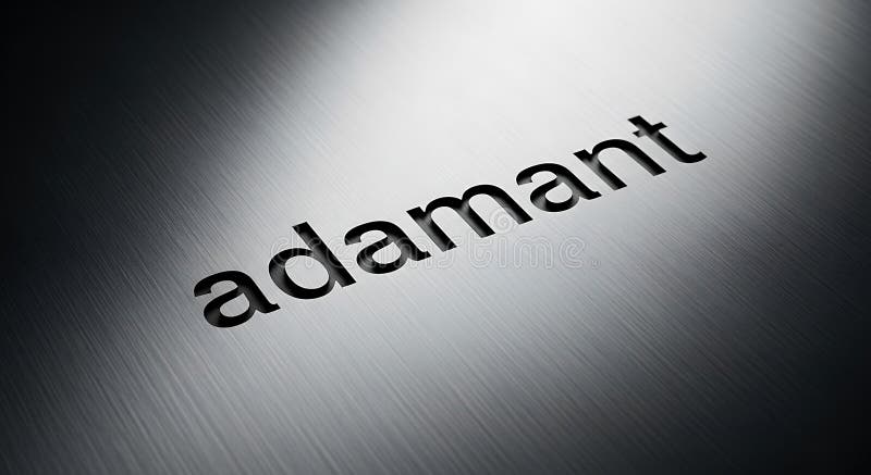 The image displays the word \'adamant\' engraved on a surface with a metallic, brushed stock illustration