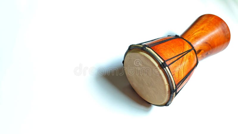 This image features a beautifully handcrafted wooden drum, similar to a small djembe, placed on a clean white surface. royalty free stock image
