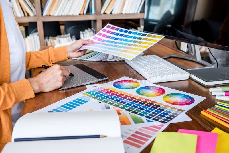 Image of female creative graphic designer working on color selection and drawing on graphics tablet at workplace with work tools stock image Image of female creative graphic designer working on color selection and drawing on graphics tablet at workplace with work tools stock image