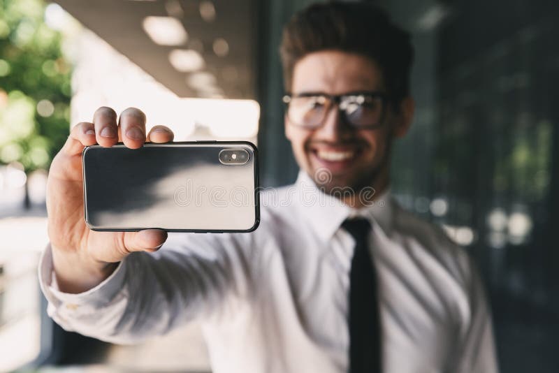 Business man near business center using mobile phone take a selfie. stock photo Business man near business center using mobile phone take a selfie. stock photo