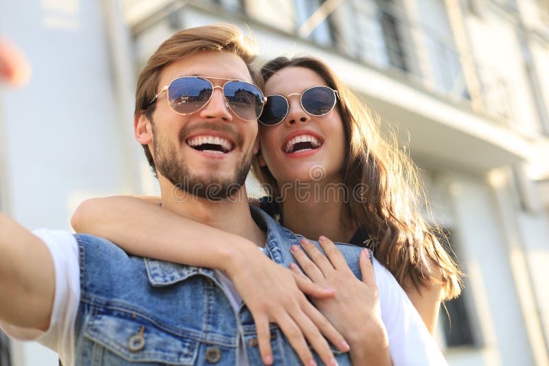 Image of a happy smiling cheerful young couple outdoors take a selfie by camera. stock image Image of a happy smiling cheerful young couple outdoors take a selfie by camera. stock image