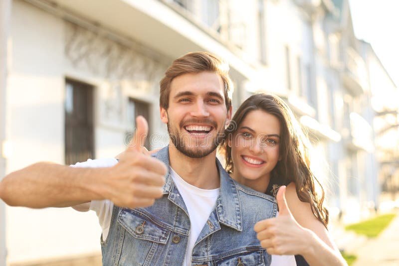 Image of a happy smiling cheerful young couple outdoors take a selfie by camera. royalty free stock photo Image of a happy smiling cheerful young couple outdoors take a selfie by camera. royalty free stock photo