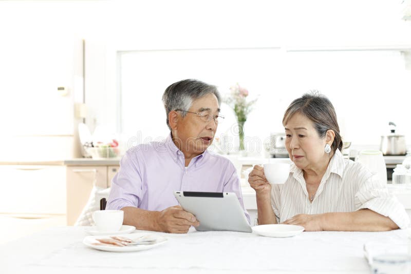 Japanese senior couple, enjoying coffee in the kitchen at home