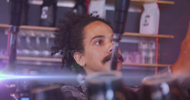 Image of light spots over biracial man working at cafe stock images