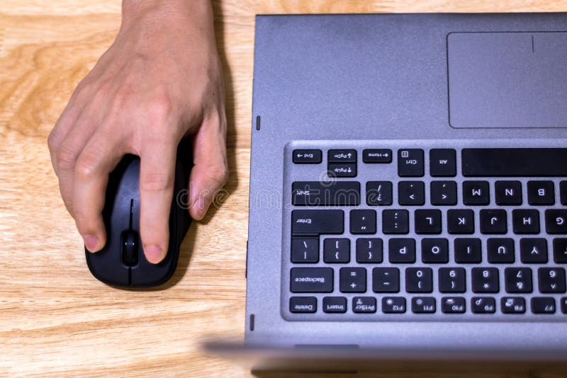 Hand Using Computer Mouse and Laptop on Desk stock photo Hand Using Computer Mouse and Laptop on Desk stock photo