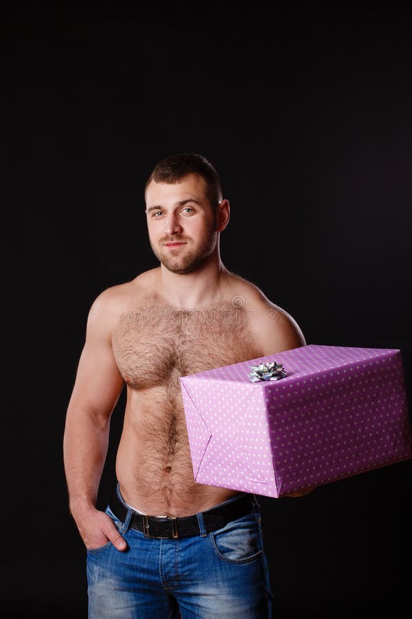 Image of muscular man holding xmas gifts, isolated on black