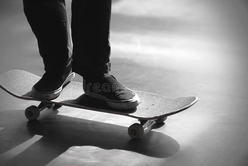 Image noire et blanche des jambes d'une équitation d'homme sur sa planche à roulettes images libres de droits Image noire et blanche des jambes d'une équitation d'homme sur sa planche à roulettes images libres de droits