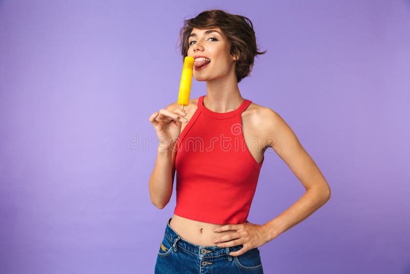 Image of positive cute woman 20s in casual wear smiling and eating ice cream, isolated over violet background stock images Image of positive cute woman 20s in casual wear smiling and eating ice cream, isolated over violet background stock images