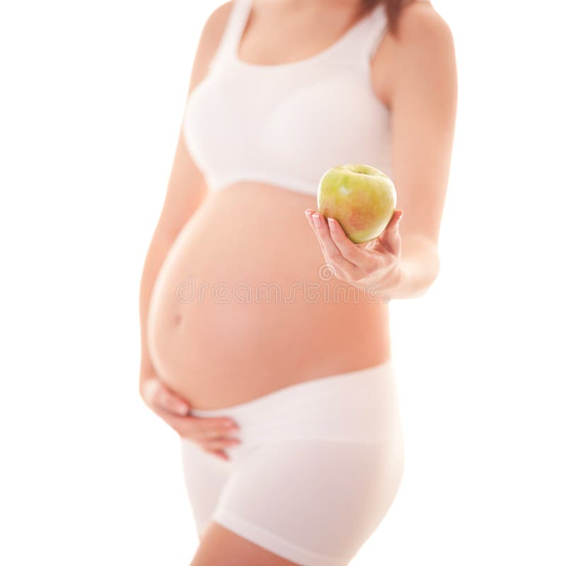 Image of pregnant woman touching her big belly and holding apple in the hand isolated on white background. Close up. Beautiful stock photography Image of pregnant woman touching her big belly and holding apple in the hand isolated on white background. Close up. Beautiful stock photography