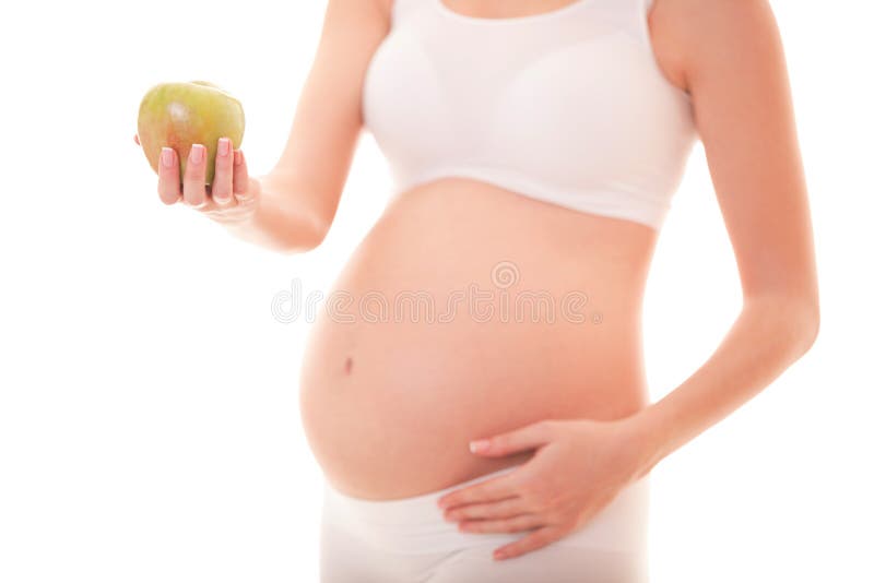 Image of pregnant woman touching her big belly and holding apple in the hand isolated on white background. Close up. Beautiful royalty free stock images Image of pregnant woman touching her big belly and holding apple in the hand isolated on white background. Close up. Beautiful royalty free stock images