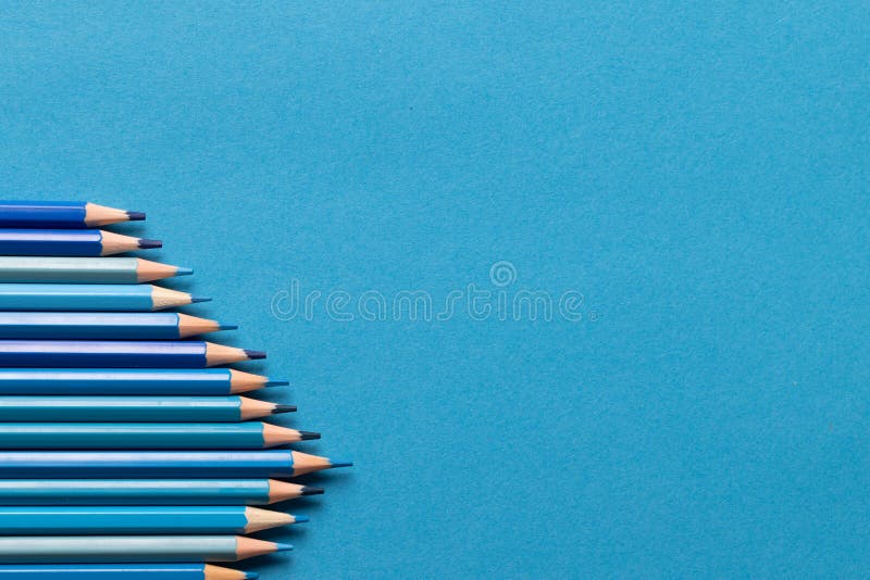 Image of Row of Different Shades of Blue Crayons on Blue Background