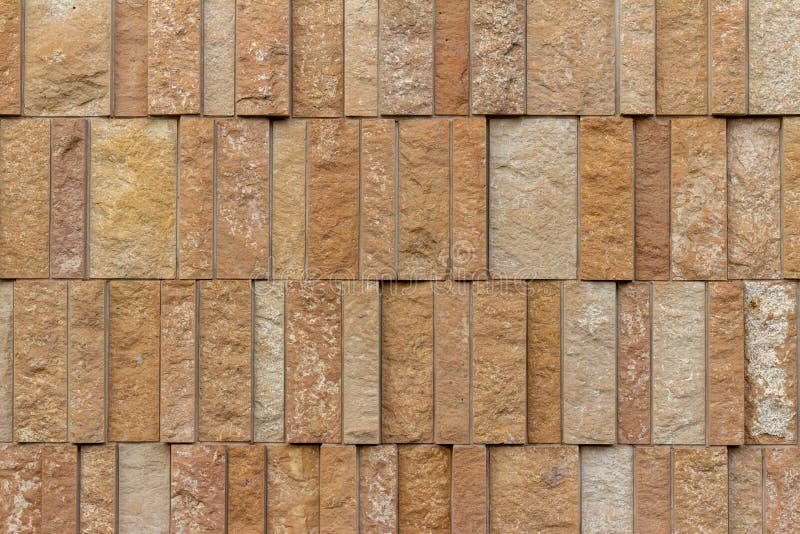 Modern rough textured limestone wall background with vertical aligned stone bricks