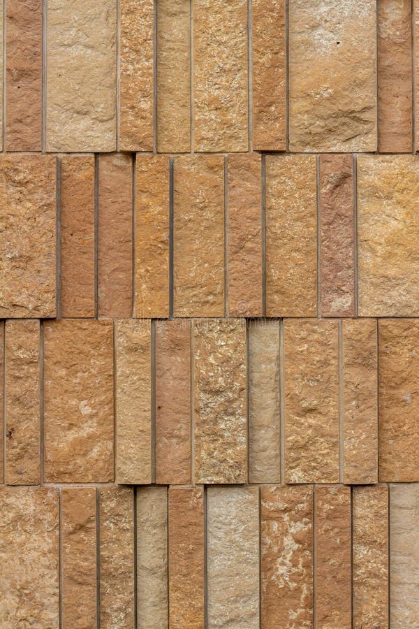 Modern rough textured limestone wall background with vertical aligned stone bricks