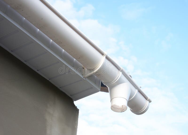 White PVC Roof Gutter System Installation on House Exterior with Drainage Pipe royalty free stock images