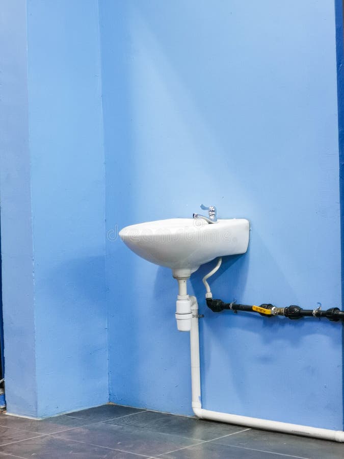Image of Single Basin or Bowl Ceramic Sink Against Blue Concrete Wall