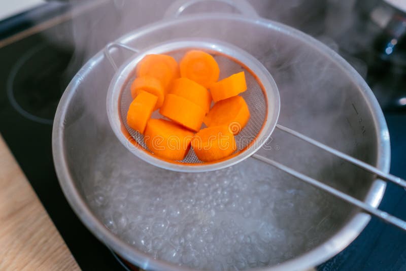 The Image of a Small Amount of Chopped Carrots Over a Boiling Pan Stock