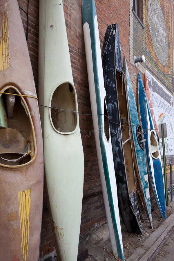 Profile image of stacked weathered worn rustic old time kayaks
