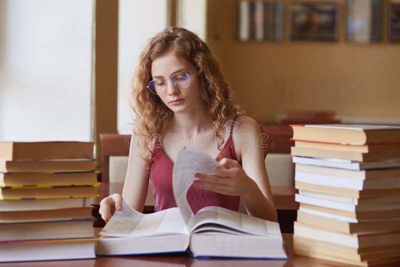 Image of thoughtful hard working young girl turning over pages of huge book, searching for proper information for study project, royalty free stock photos Image of thoughtful hard working young girl turning over pages of huge book, searching for proper information for study project, royalty free stock photos