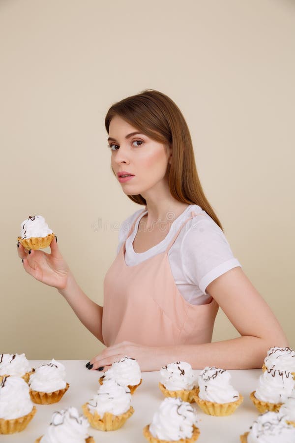Image verticale de la femme par la table mangeant des gâteaux photo libre de droits