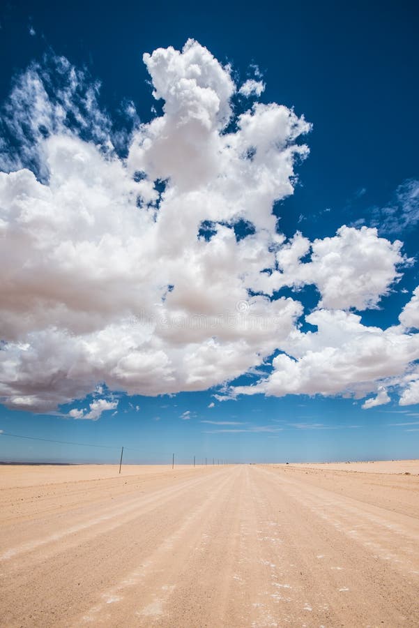 Image vibrante de route de désert et de ciel nuageux bleu photographie stock Image vibrante de route de désert et de ciel nuageux bleu photographie stock